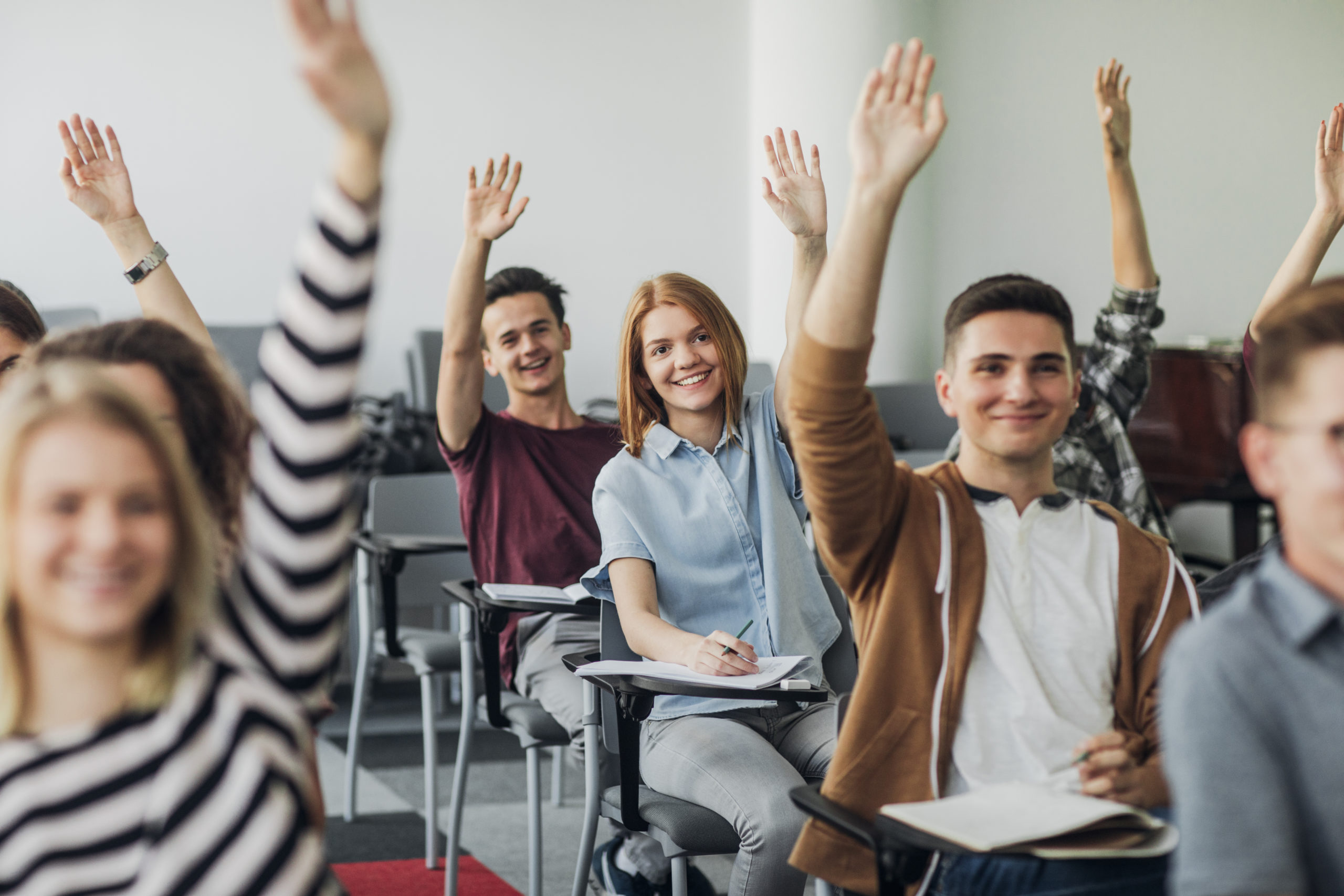 Students Raising hands in a classroom