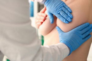 Gloved doctor performing clinical exam